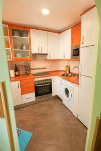 a kitchen with white cabinets and a washing machine at El rincón de Arévalo in Arévalo