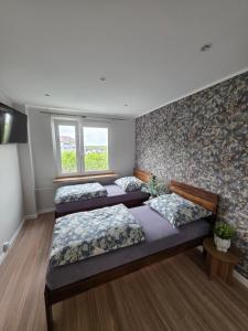 a room with three beds and a window at Apartament dla 7 osób in Głogów