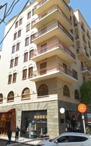 a tall white building with a car parked in front of it at Republic Square Apartment in Yerevan