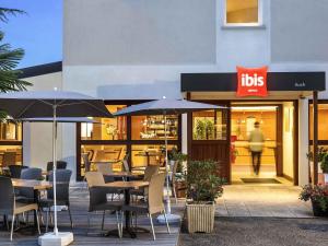 a restaurant with tables and chairs and umbrellas at ibis Auch in Auch