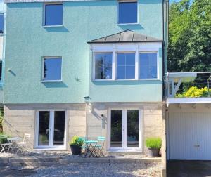 a blue house with white windows and a garage at Charmante Waldrandidylle in Kreuzlingen