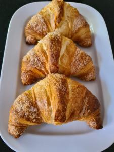 three croissants on a white plate on a table at La casa di Hermes in Imola