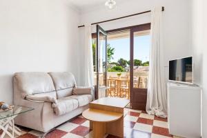 a living room with a couch and a tv at Las Belisas in Arenal d'en Castell