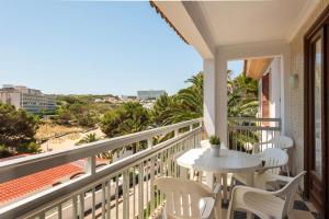 a balcony with a table and chairs and a view of the beach at Las Belisas in Arenal d'en Castell