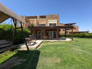 a house with a yard with a bench in front of it at Florence Chalet in Marina Wadi Degla Ain Sokhna - Ground floor with 360 Sqm with Private Garden in Ain Sokhna
