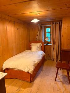 a bedroom with a bed in a wooden room at Chalet de montagne sur le TMB in La Fouly