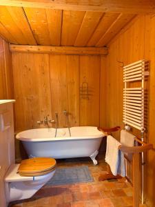 a bathroom with a white tub and a wooden ceiling at Chalet de montagne sur le TMB in La Fouly