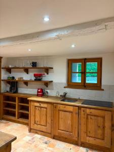 a kitchen with wooden cabinets and a sink at Chalet de montagne sur le TMB in La Fouly +25 photos