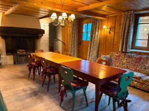 a dining room with a wooden table and chairs at Chalet de montagne sur le TMB in La Fouly