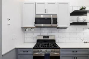 a white kitchen with a stove and a microwave at Stylish Birmingham Loft + Rooftop Lounge in Birmingham