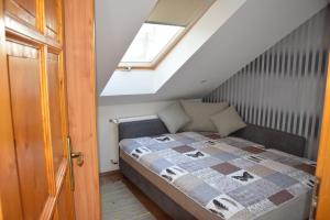 a bed in a small room with a window at Nóra Wellness nyaraló in Ábrahámhegy