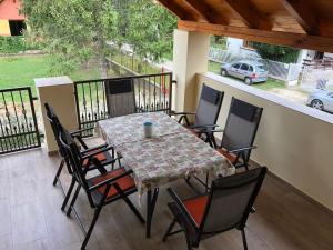 a table and chairs on a balcony with a car at Nóra Wellness nyaraló in Ábrahámhegy