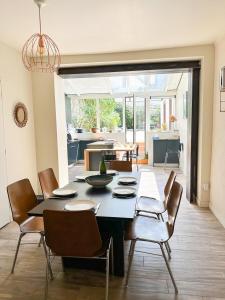 a dining room with a table and chairs and a kitchen at Les Soupières in Fécamp