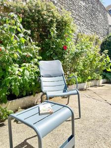 a blue chair sitting in front of some bushes at Les Soupières in Fécamp +39 photos