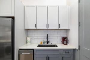 a kitchen with white cabinets and a sink at Stylish Birmingham Loft + Rooftop Lounge in Birmingham