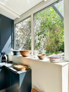 a window in a kitchen with bowls and plates on a counter at Les Soupières in Fécamp