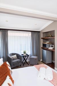 a bedroom with a bed and a couch and a chair at 178 Club in Pretoria
