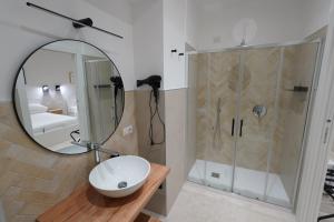 a bathroom with a sink and a shower with a mirror at ResidenzaMarèa in Scalea +2 photos
