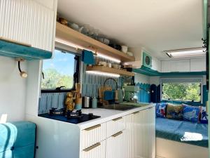 a kitchen in an rv with a sink and a stove at Boho luxury caravan in Kisapáti +8 photos