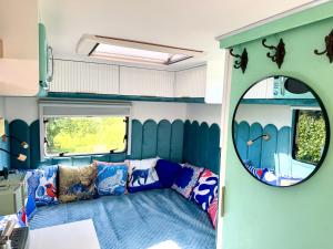 a living room with a couch and a mirror at Boho luxury caravan in Kisapáti