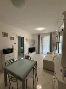 a living room with a table and a couch at Appartamento ELDORADO in Lido di Pomposa
