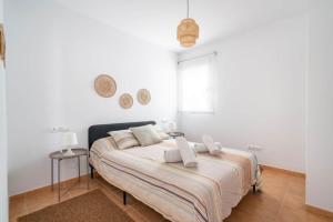 a bedroom with a bed with white walls and a window at MarLau Breeze in Mojácar