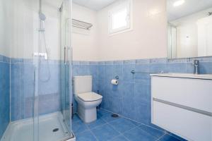 a blue tiled bathroom with a toilet and a shower at MarLau Breeze in Mojácar