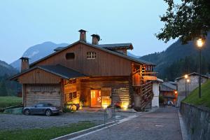 a barn with a car parked in front of it at Hotel Garni Plueme in Sauris