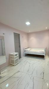 a white room with a bed and a table at Chácara encantos Iranduba in Iranduba