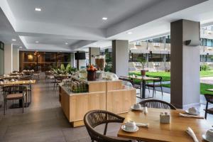 ein Restaurant mit Holztischen und -stühlen und einer Cafeteria in der Unterkunft Best Western Plus Hotel Terraza in San Salvador