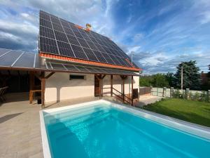a house with a swimming pool with a solar roof at Garden Spa Resort in Budapest