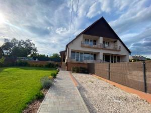 a house with a fence and a grass yard at Garden Spa Resort in Budapest