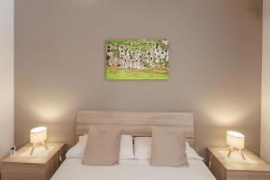 a bedroom with a bed with two nightstands and two lamps at Casa Lina - 10 minuti da Pantalica-parcheggio gratuito in Sortino
