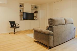 a living room with a couch and a chair and a television at Gerês Thermal Escape in Geres