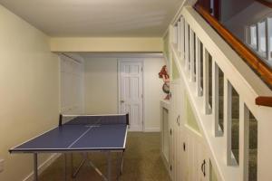 a ping pong table in a room with a staircase at Minutes to Oceanside Beaches in Eastham