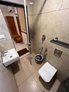 a bathroom with a shower and a toilet and a sink at Hotel LIORA GRAND in Bangalore