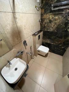 a bathroom with a sink and a toilet at Hotel LIORA GRAND in Bangalore +8 photos