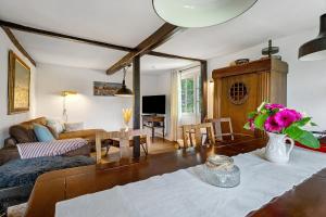 a living room with a couch and a table with flowers at Reetdachkate in Esgrus