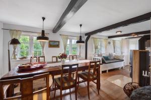 a kitchen and living room with a table and chairs at Reetdachkate in Esgrus