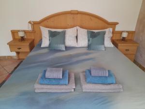 a bed with three pillows on top of it at Di Baut in Ovaro