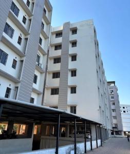 ein großes weißes Gebäude mit einer Markise davor in der Unterkunft Transit Nest 1BHK in Guwahati + 10 Fotos