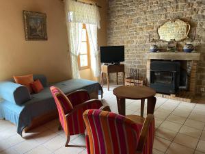 a living room with a couch and a fireplace at Château de Villeron in Savigny-en-Revermont