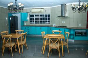 a kitchen with blue cabinets and a table and chairs at Kariebi Guest House in Bethlehem +16 photos