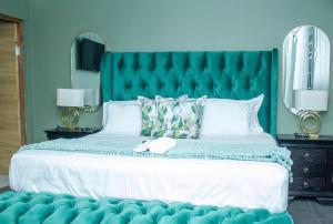 a bedroom with a large bed with a blue headboard at Kariebi Guest House in Bethlehem