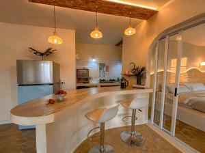 a kitchen with a large island with two bar stools at Thara Coco Villa - Boutique Luxury In Srithanu in Hinkong