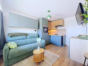 a living room with a couch and a table at Stella Plage, Studio Vert et Mer in Cucq