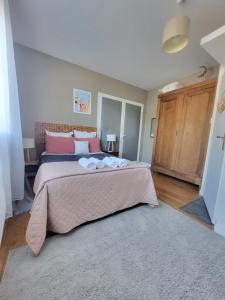 a bedroom with a large bed with pink pillows at "Les Logis d'Argent Mimizan Chambre d'hôte climatisée avec WC, SDB, TV, Wifi, Option Petit Déjeuner , Parking in Mimizan +50 photos