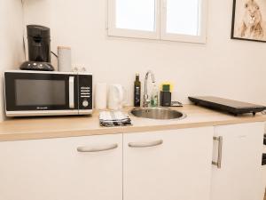 a kitchen counter with a microwave and a sink at Road Stop Studio - Paris - Disney- Train Station in Chelles