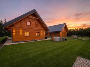 a wooden house with a lawn in front of it at Chalupa Sandra in Vítějeves