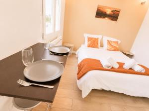 a bedroom with a table and a large bed at Road Stop Studio - Paris - Disney- Train Station in Chelles